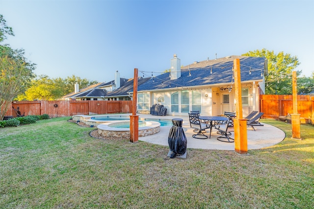 back of property featuring a patio, a pool with hot tub, and a lawn