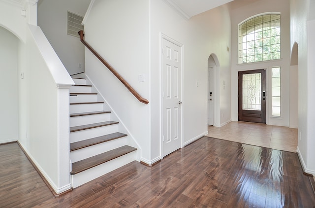 entrance foyer with a high ceiling, ornamental molding, and dark hardwood / wood-style floors