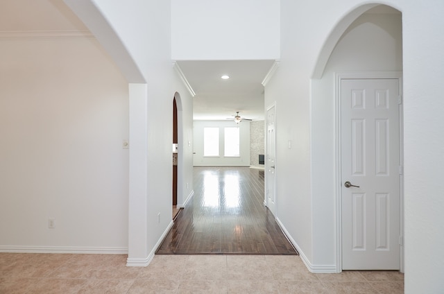 hall with light wood-type flooring and ornamental molding