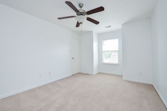 carpeted spare room featuring ceiling fan