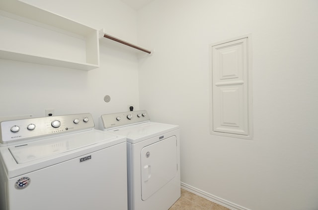 washroom featuring washing machine and dryer and light tile patterned floors