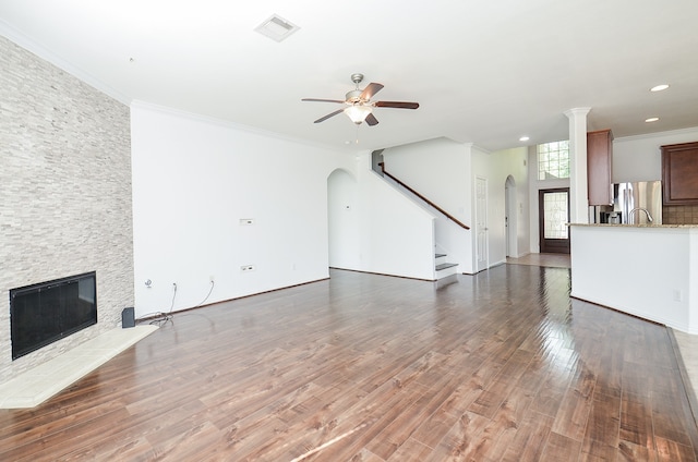 unfurnished living room featuring ceiling fan, dark hardwood / wood-style flooring, and ornamental molding