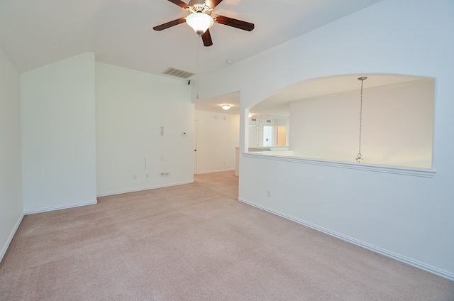 spare room featuring vaulted ceiling, light colored carpet, and ceiling fan