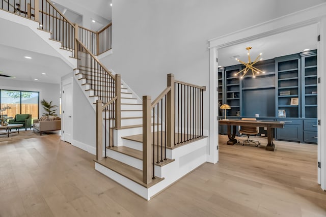 staircase featuring an inviting chandelier and hardwood / wood-style flooring