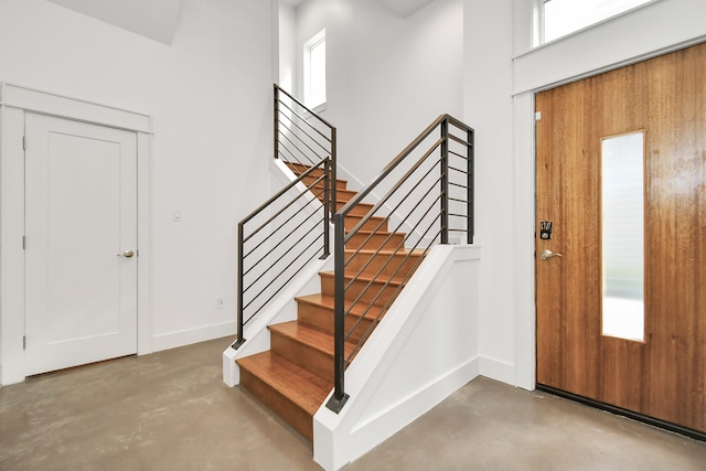 entryway featuring a towering ceiling and a wealth of natural light