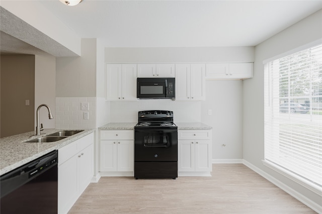 kitchen featuring light stone countertops, white cabinetry, sink, and black appliances