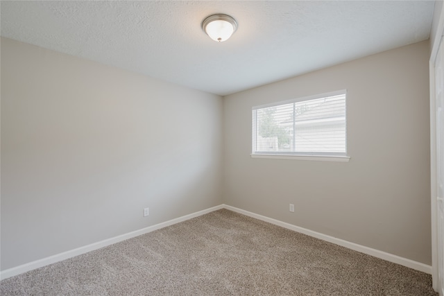 carpeted spare room featuring a textured ceiling