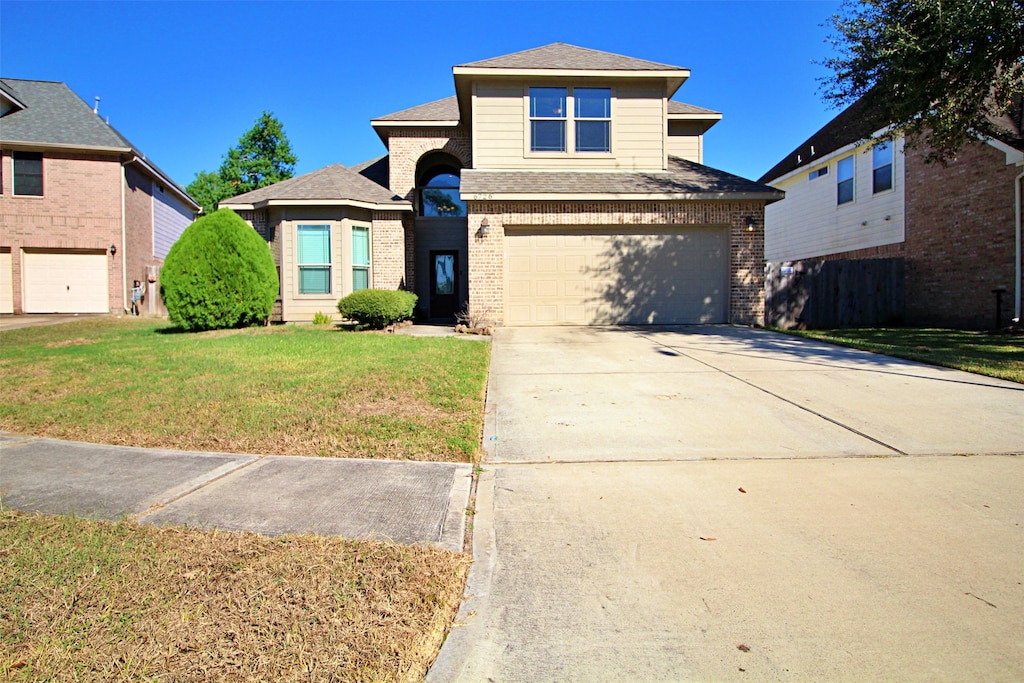 view of property with a garage and a front lawn