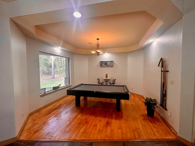 recreation room with a raised ceiling, billiards, and hardwood / wood-style flooring