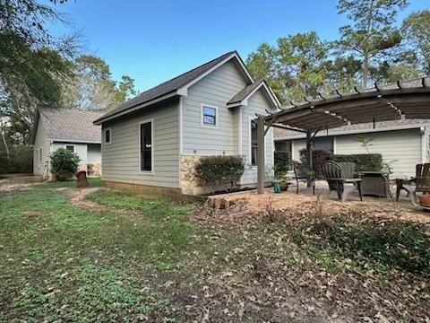 rear view of property featuring a pergola and a yard