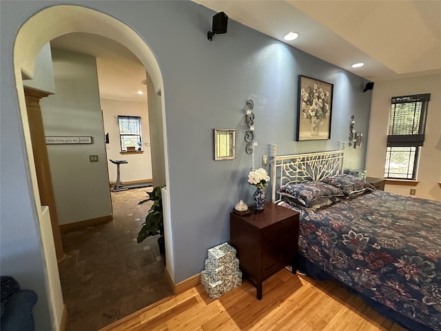 bedroom featuring multiple windows and hardwood / wood-style flooring