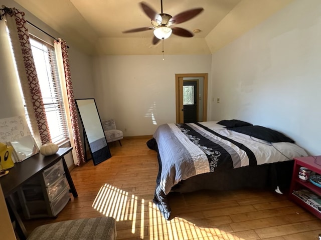 bedroom with light wood-type flooring, vaulted ceiling, and ceiling fan