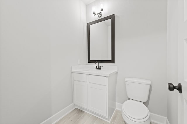 bathroom featuring wood-type flooring, vanity, and toilet