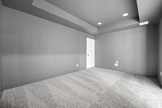 carpeted empty room featuring a tray ceiling