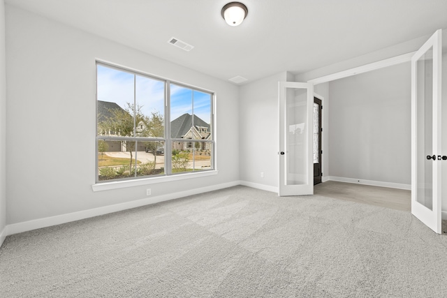 unfurnished bedroom featuring french doors and carpet