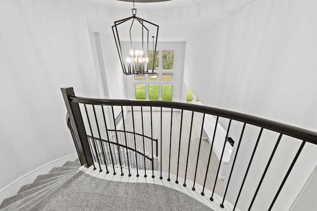 stairs featuring a chandelier and carpet flooring