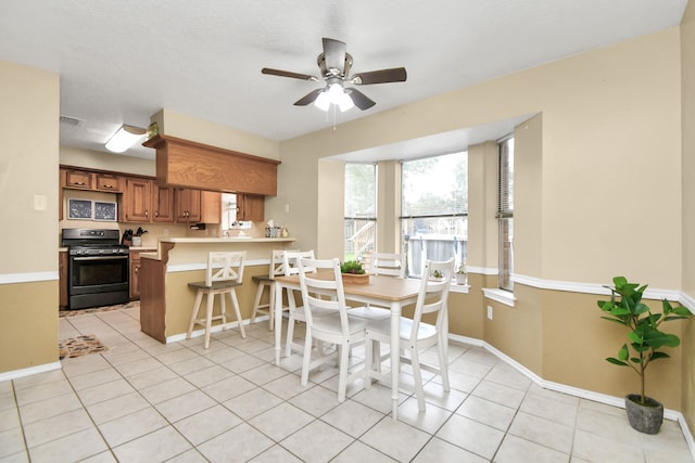 dining space featuring ceiling fan and light tile patterned flooring