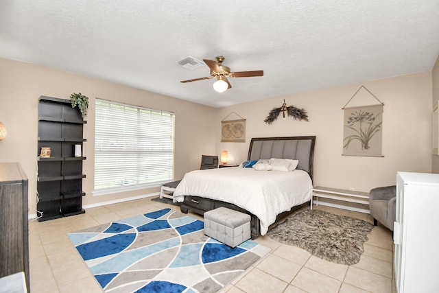 bedroom featuring light tile patterned floors, a textured ceiling, and ceiling fan