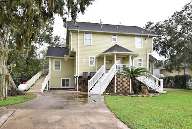 view of front of home featuring a front lawn, central AC unit, and a porch