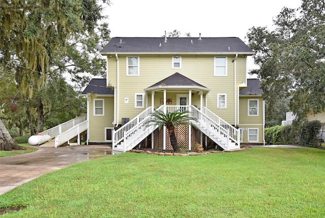 rear view of house with a yard and covered porch