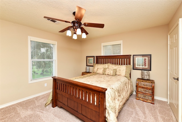 carpeted bedroom featuring a textured ceiling and ceiling fan