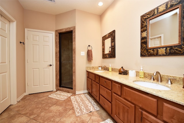 bathroom with an enclosed shower, vanity, a textured ceiling, and tile patterned floors