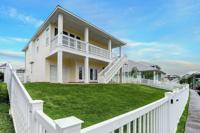 back of house featuring a balcony and a yard