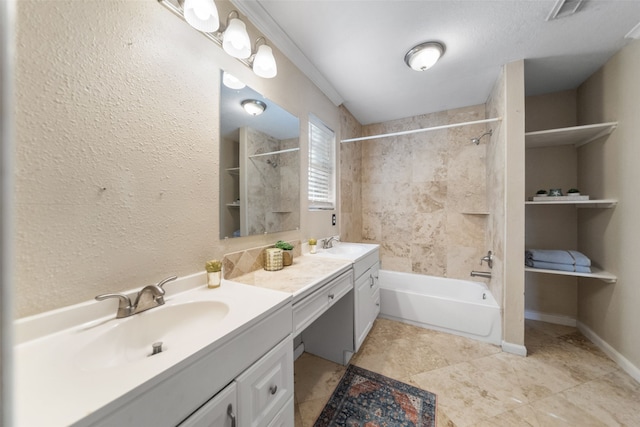 bathroom featuring vanity, a textured ceiling, and tiled shower / bath