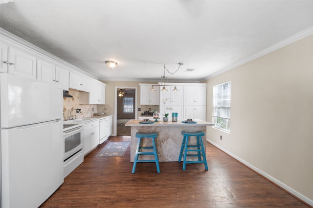 kitchen featuring a kitchen island, white cabinetry, dark hardwood / wood-style flooring, a kitchen breakfast bar, and white appliances