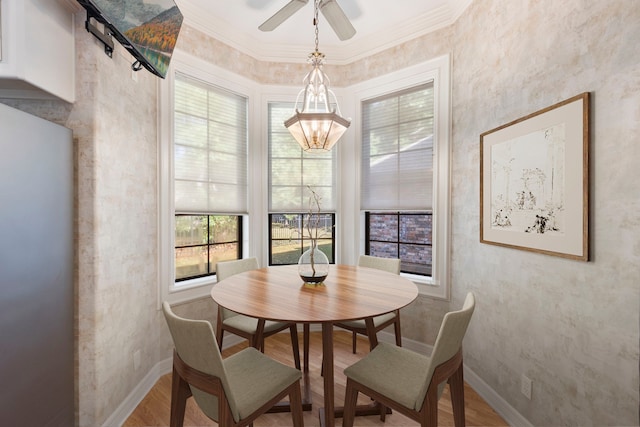 dining room featuring ceiling fan with notable chandelier, ornamental molding, and hardwood / wood-style flooring