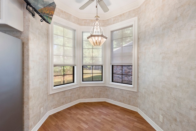 unfurnished dining area with hardwood / wood-style flooring, ceiling fan, and crown molding