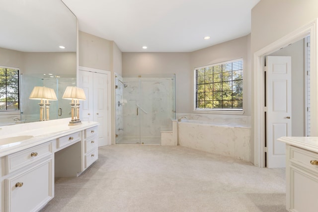 bathroom featuring vanity, separate shower and tub, and a healthy amount of sunlight