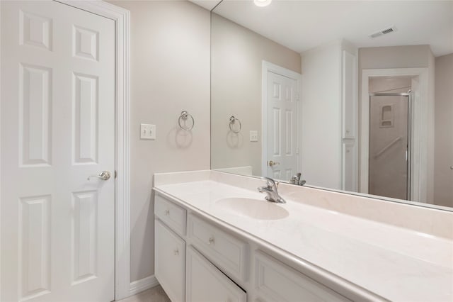 bathroom featuring vanity and a shower with shower door