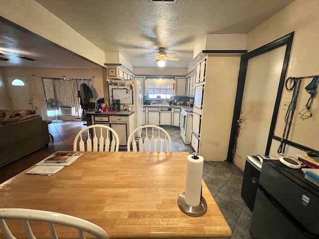 tiled dining room featuring a textured ceiling and ceiling fan