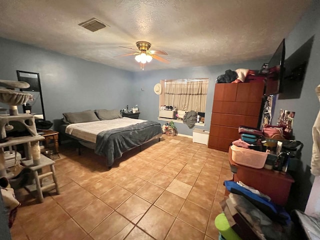 tiled bedroom with a textured ceiling and ceiling fan