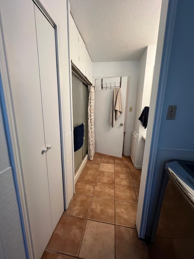 bathroom with tile patterned flooring and a textured ceiling