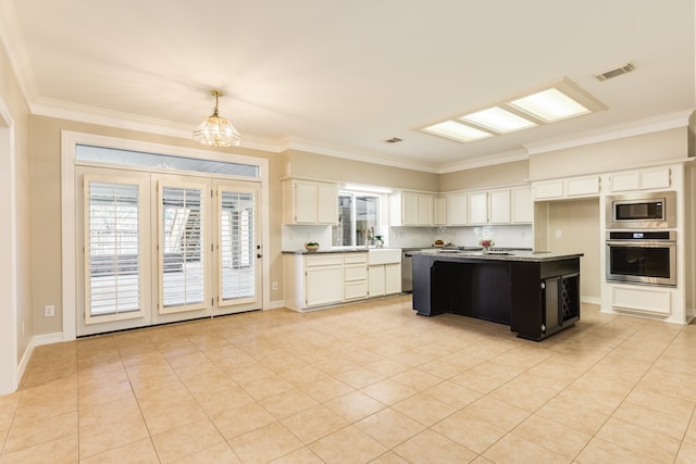 kitchen with white cabinetry, stainless steel appliances, an island with sink, a chandelier, and decorative light fixtures