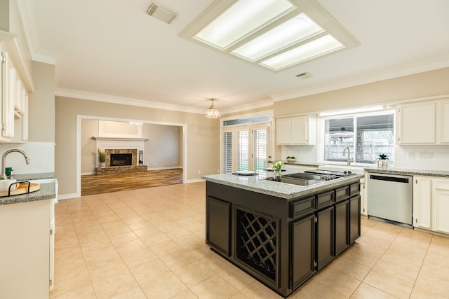 kitchen with light stone countertops, dishwasher, white cabinets, and a kitchen island