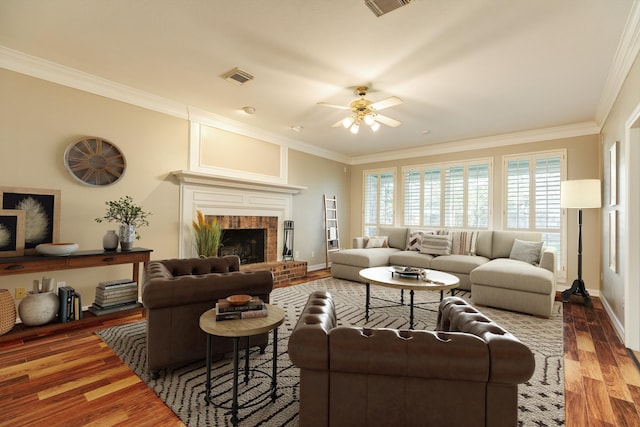 living room featuring a fireplace, ceiling fan, dark hardwood / wood-style flooring, and crown molding