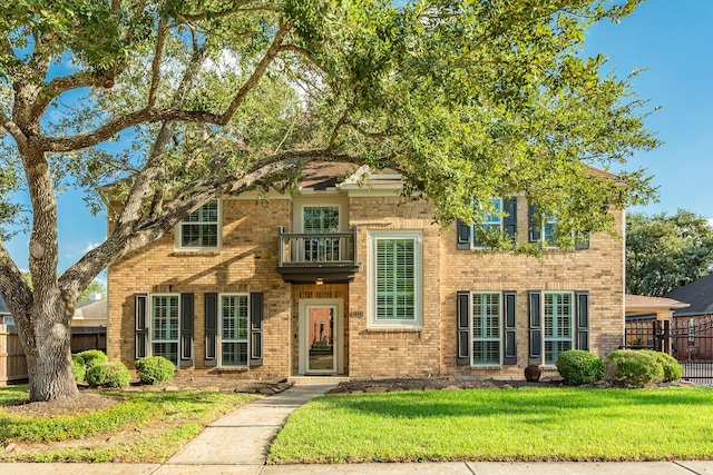 view of front facade with a balcony and a front yard