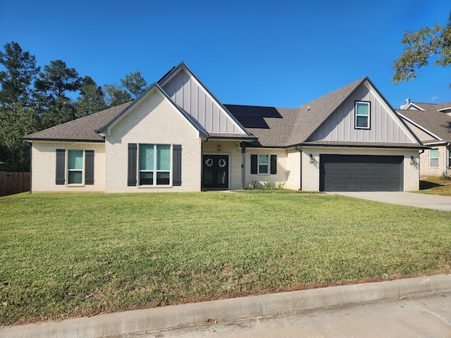 view of front of house featuring a garage, a front yard, and solar panels