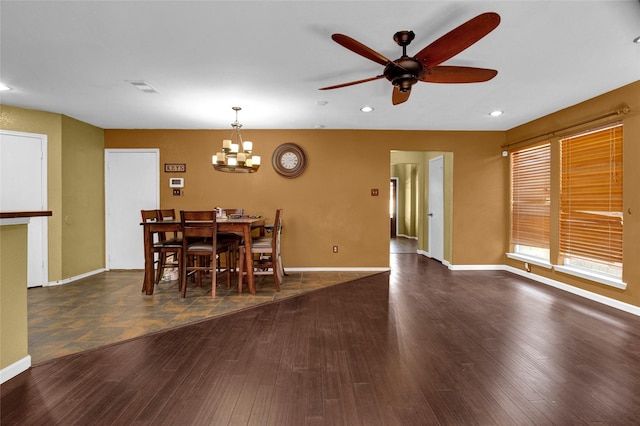 dining room with ceiling fan with notable chandelier and dark hardwood / wood-style floors