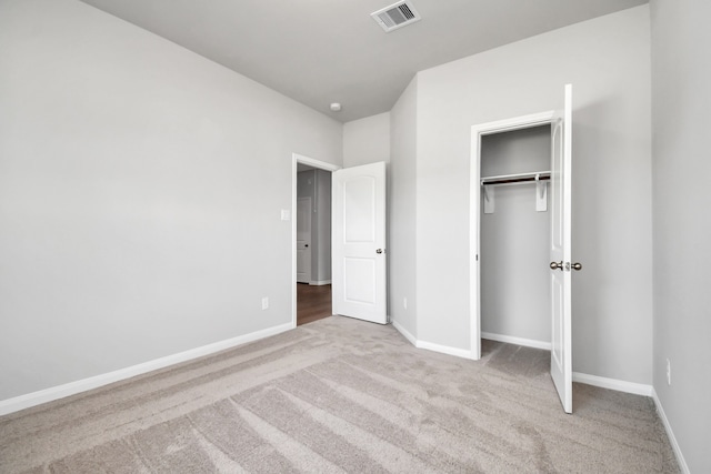 unfurnished bedroom featuring a closet and light carpet