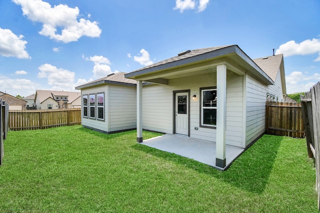 back of house with a lawn and a patio