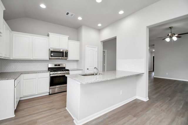 kitchen with kitchen peninsula, white cabinets, sink, and stainless steel appliances