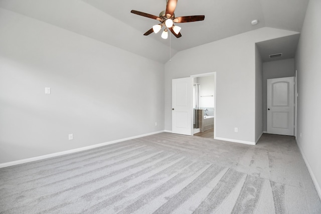 unfurnished bedroom with ceiling fan, ensuite bath, lofted ceiling, and light colored carpet