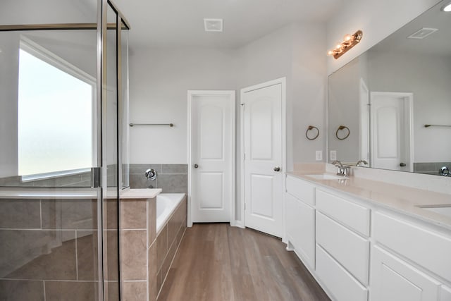 bathroom featuring shower with separate bathtub, vanity, and wood-type flooring