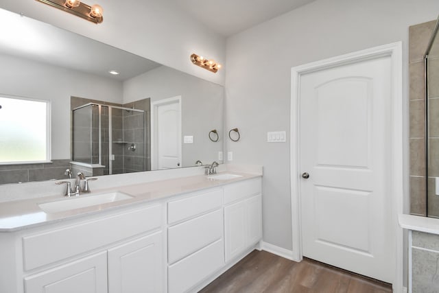 bathroom with an enclosed shower, vanity, and hardwood / wood-style flooring