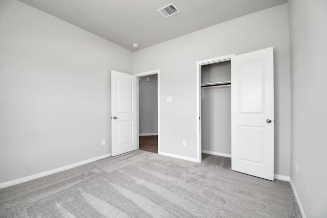 unfurnished bedroom featuring light colored carpet and a closet