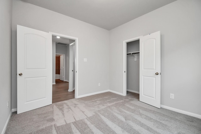 unfurnished bedroom with light carpet and a closet